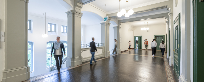 Bannerbild LLBM - Mitarbeitende und Studierende am Infodesk im Sekretariat